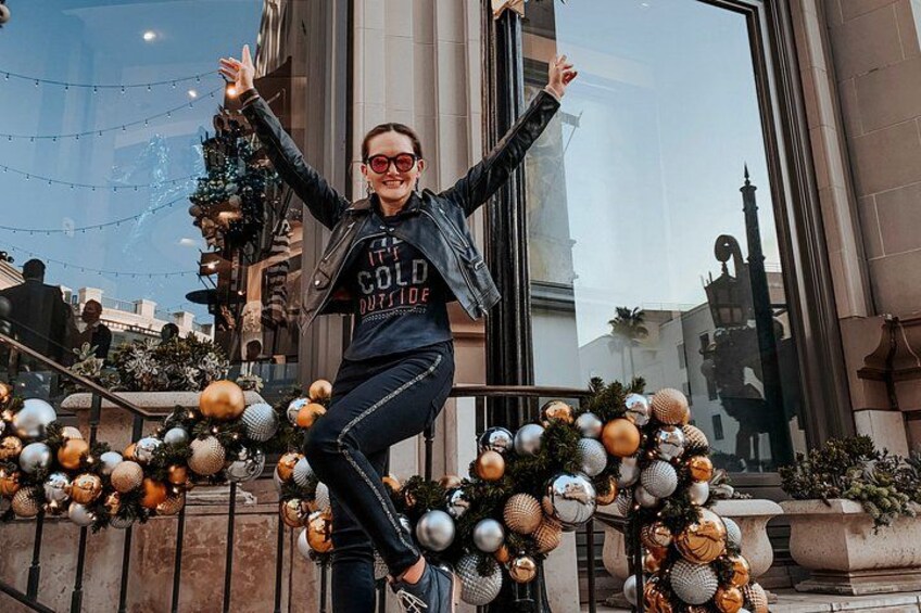 A person standing on a balcony with a festive garland of ornaments. 5