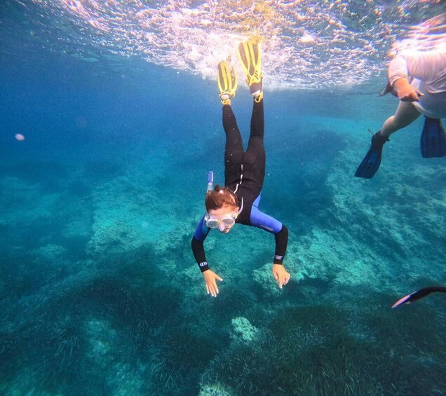 A person scuba diving underwater with fins and a mask. 2