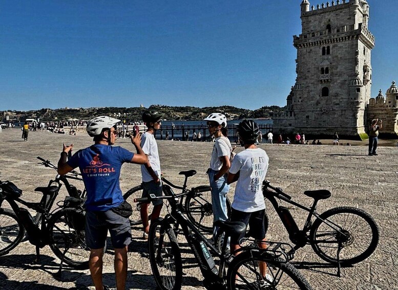 En gruppe mennesker med cykler i nærheden af et historisk tårn. 2