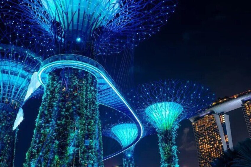A night view of a futuristic architectural structure with illuminated blue and green elements. 3