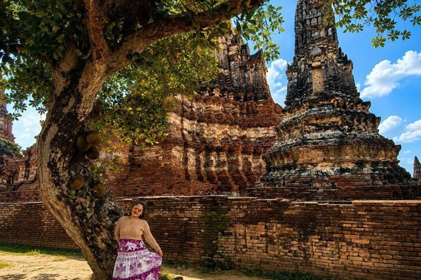 A temple with a large tree in the foreground and a clear sky. 4