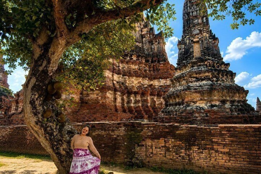 A temple with a large tree in the foreground and a clear sky. 2