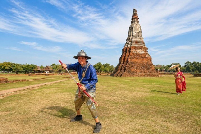 A person in traditional attire holding a red object, a large ancient stupa, and a person in red traditional dress in a grassy field. 4