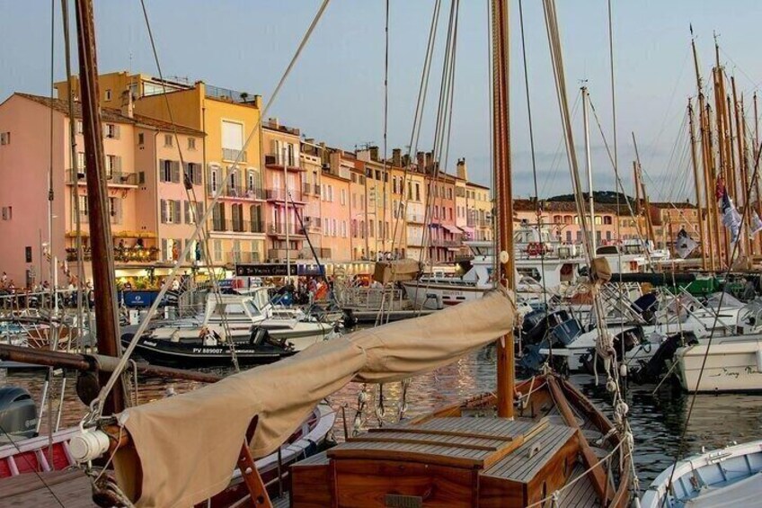 A marina with boats docked, buildings in the background, and a clear sky. 5