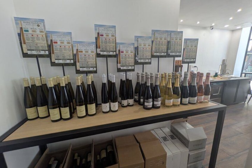 A wine tasting room with a display of wine bottles and informational cards on the wall. 5