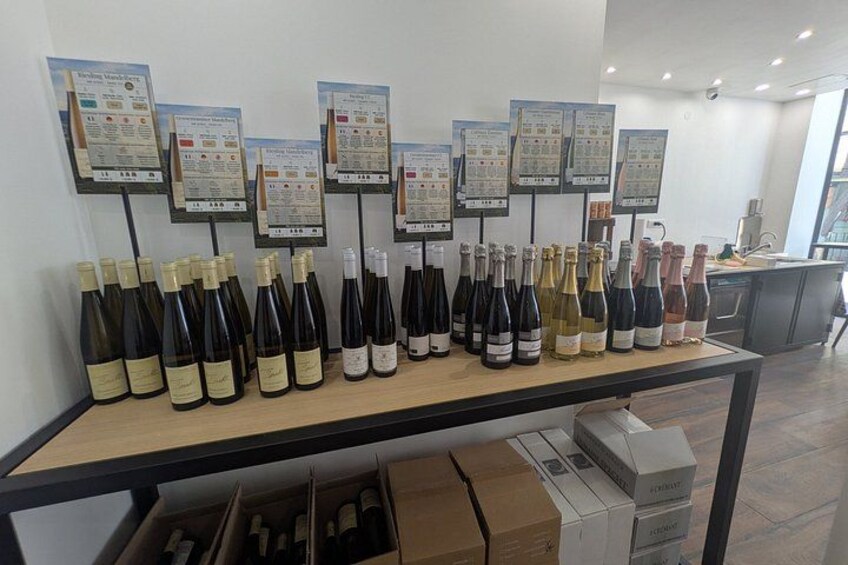 A wine tasting room with bottles on a table and tasting notes on the wall. 5