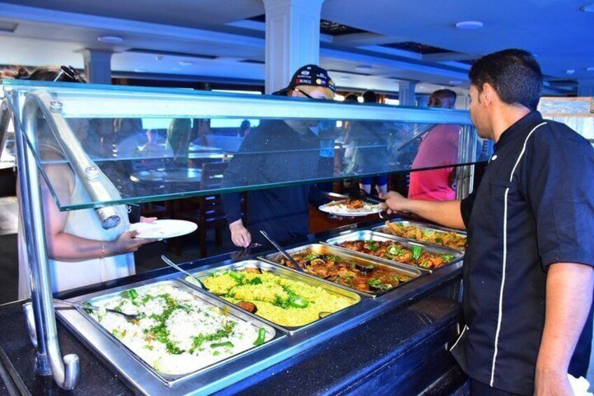 A buffet with various food options, a server, and customers. 3