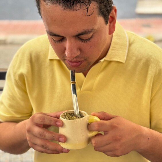 A person holding a cup with a straw, presumably drinking from it. 5