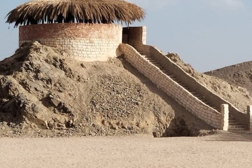 A structure with a thatched roof and a staircase leading up to it. 4