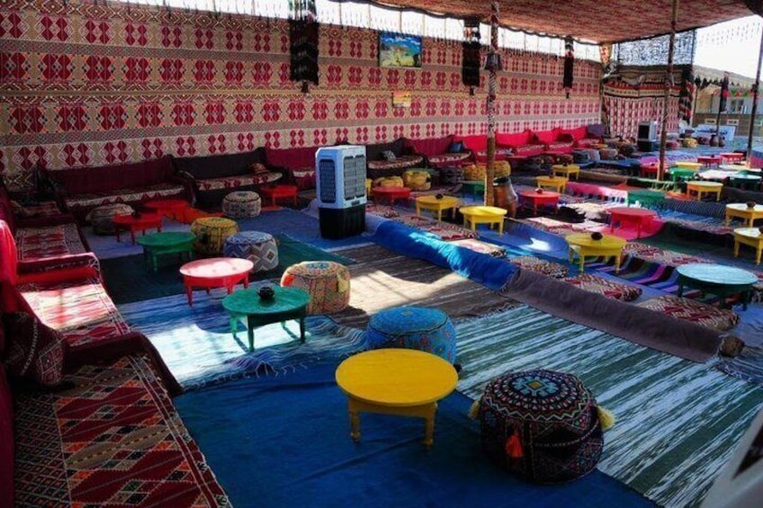 A traditional tent with colorful seating and rugs. 3