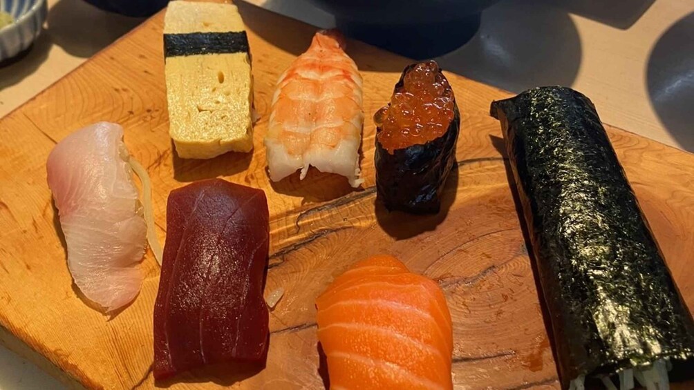 Various types of sushi on a wooden board. 3