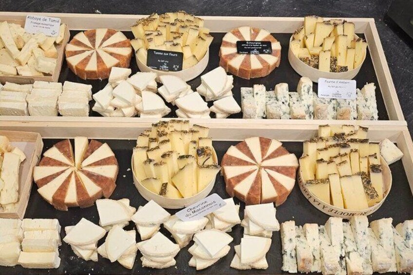 A variety of cheeses displayed in wooden trays. 1
