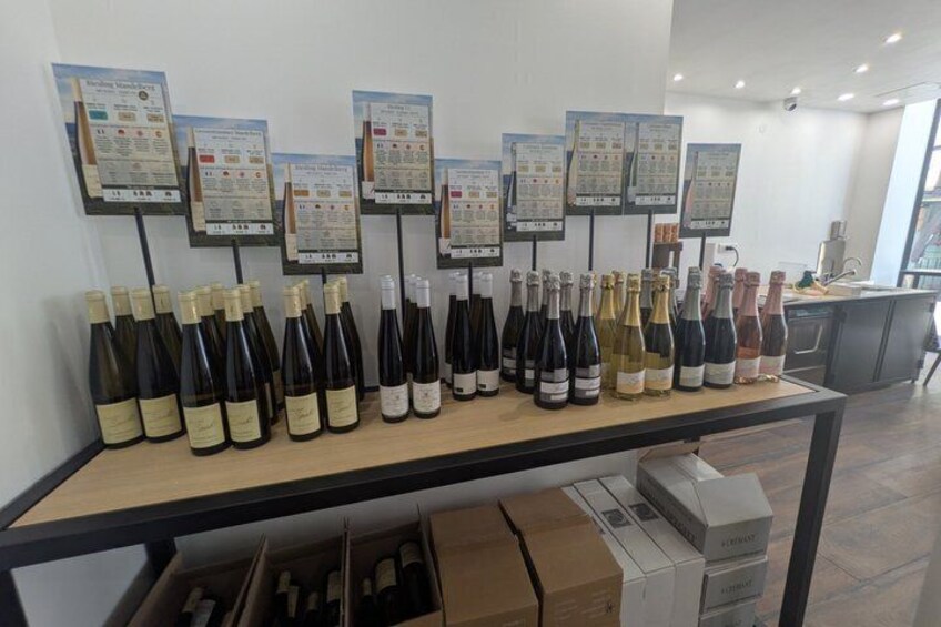 A wine tasting room with a display of wine bottles and informational cards on the wall. 3