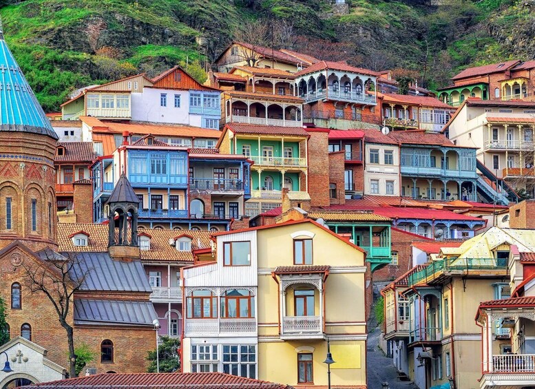 A colorful hillside town with a mix of traditional and modern architecture, including a church with a bell tower and a building with a blue dome. 3