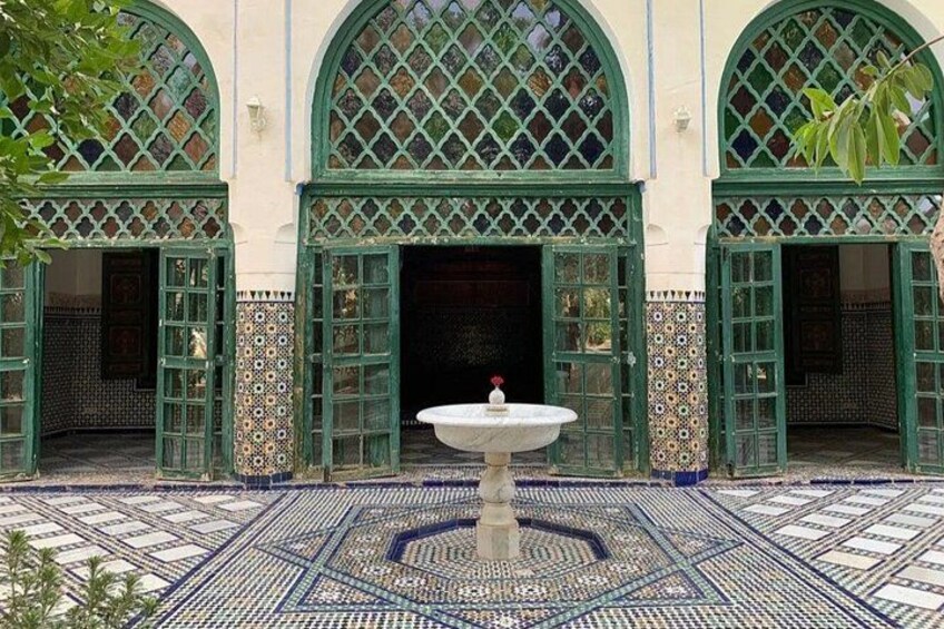 A courtyard with a fountain, arched doorways, and patterned tiles. 2