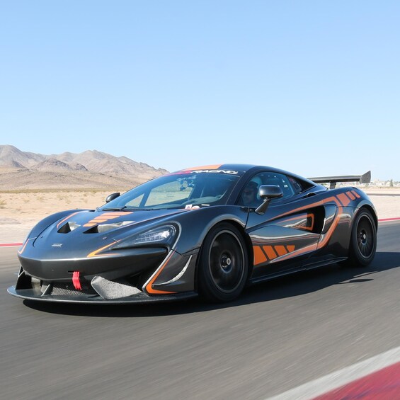 A sports car on a racetrack with desert scenery in the background. 4