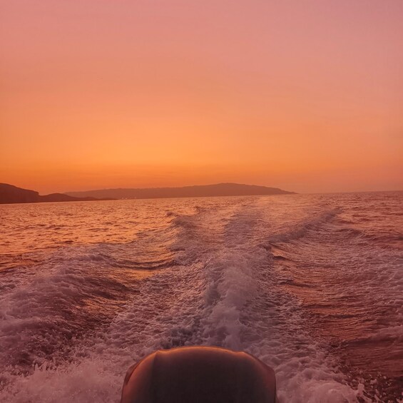 A boat's wake in a body of water during sunset. 5