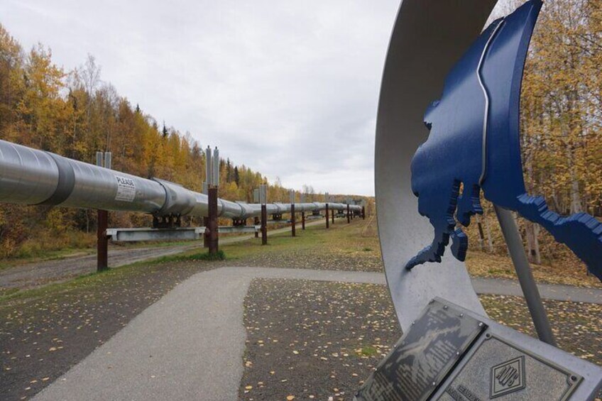 A pipeline with a blue sculpture of a human head in the foreground. 2