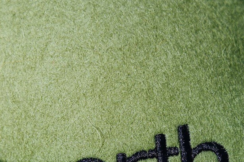 A close-up of a textured fabric with a dark embroidered design. 2