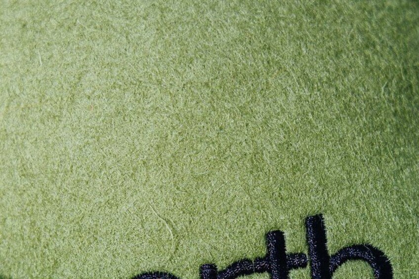 A close-up of a textured fabric with a dark embroidered design. 2