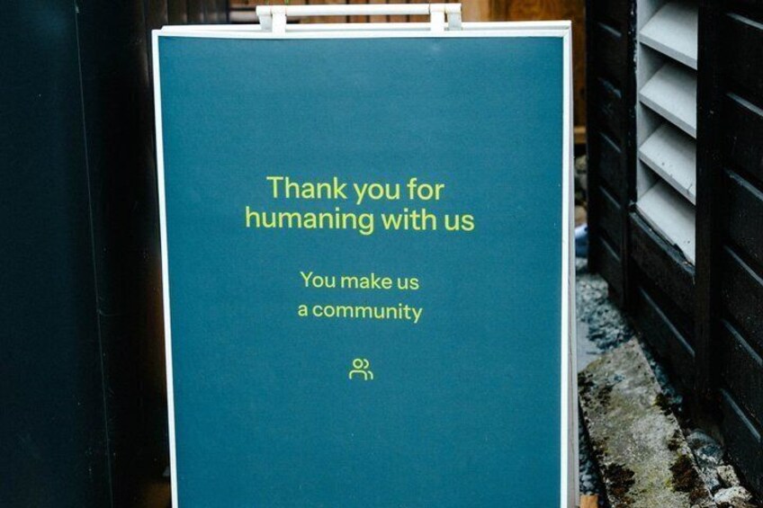 A teal sign with gold lettering expressing gratitude for community support. 4