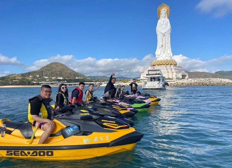 A group of people on jet skis near a large statue. 1