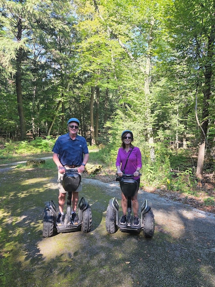 Two people on electric scooters on a forest path. 2