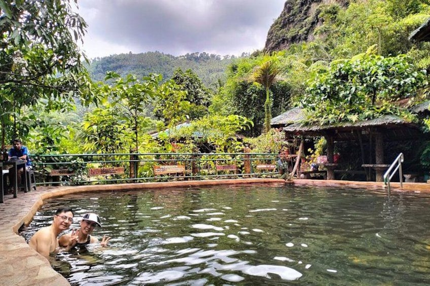 A natural pool surrounded by lush greenery and a rocky landscape. 3