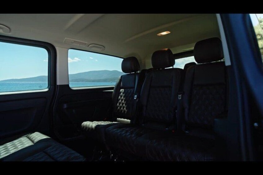 A vehicle interior with a view of the sea and mountains through the windows. 4