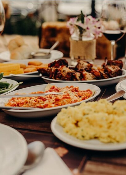A table with various dishes including pasta, meat, and mashed potatoes. 1