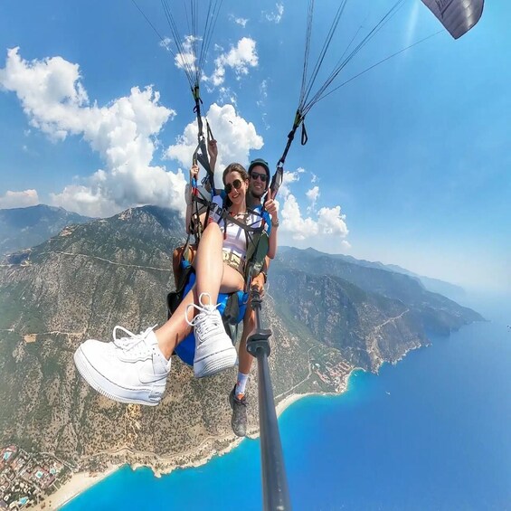 A person paragliding with a mountainous landscape and coastline in the background. 4
