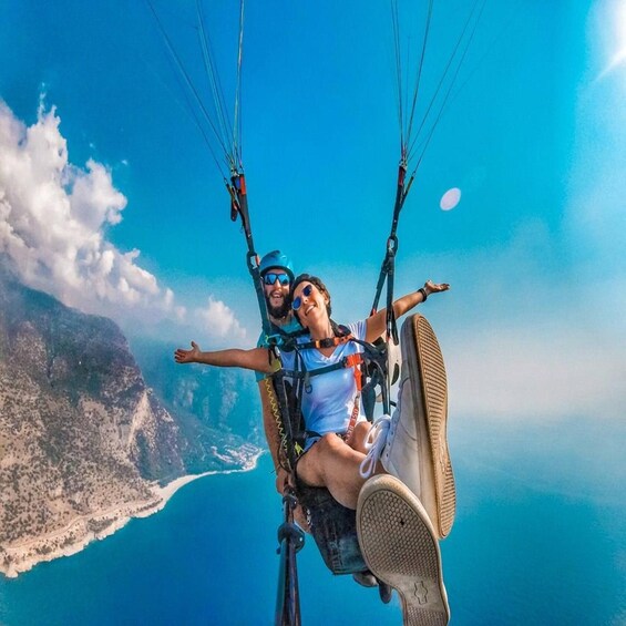 A person paragliding with a clear view of a coastline and mountains. 1