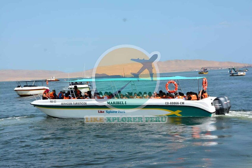 A boat named 'MARIBEL I' with passengers and lifebuoys, sailing on calm waters with other boats in the background. 5