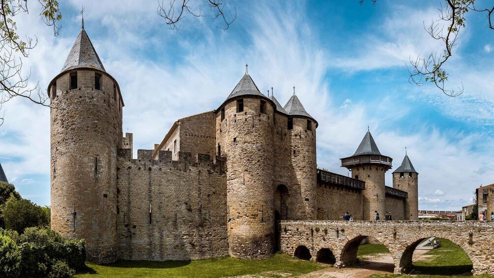 A historic stone castle with multiple towers and a stone bridge. 2