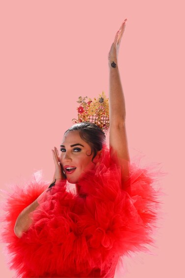 A person in a vibrant red feathered outfit with a decorative headpiece. 1