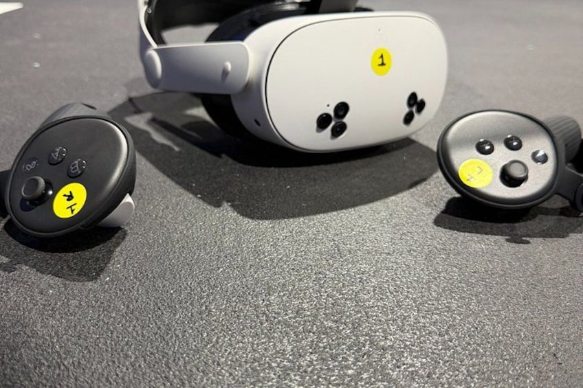 A pair of headphones with a white and black color scheme, a yellow label with the number 1, and a black circular button with a yellow symbol. 5