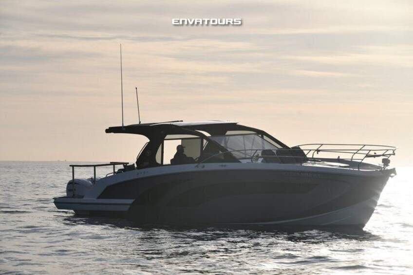 A motorboat on calm water with a clear sky. 4