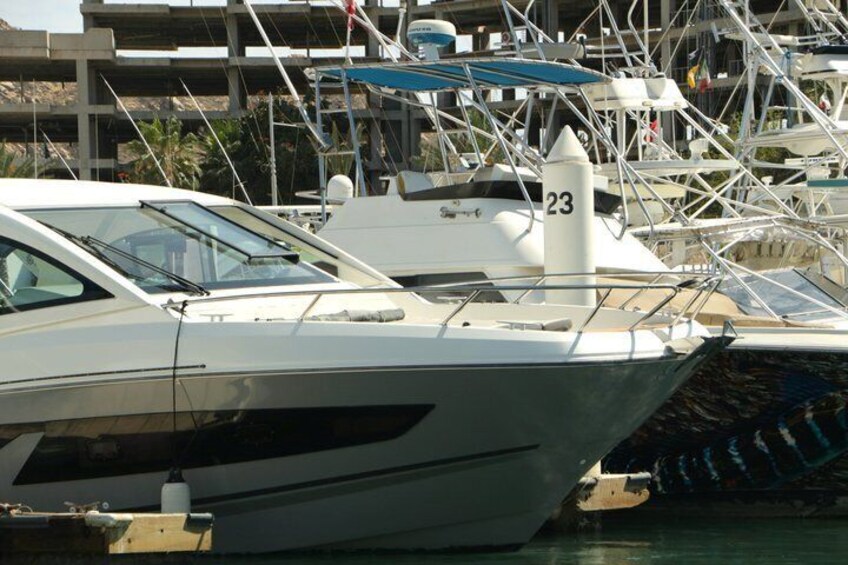 A marina with boats docked, including a white yacht with the number 23. 3