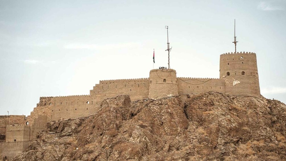 A large fortress on a rocky hill with multiple towers and flags. 2