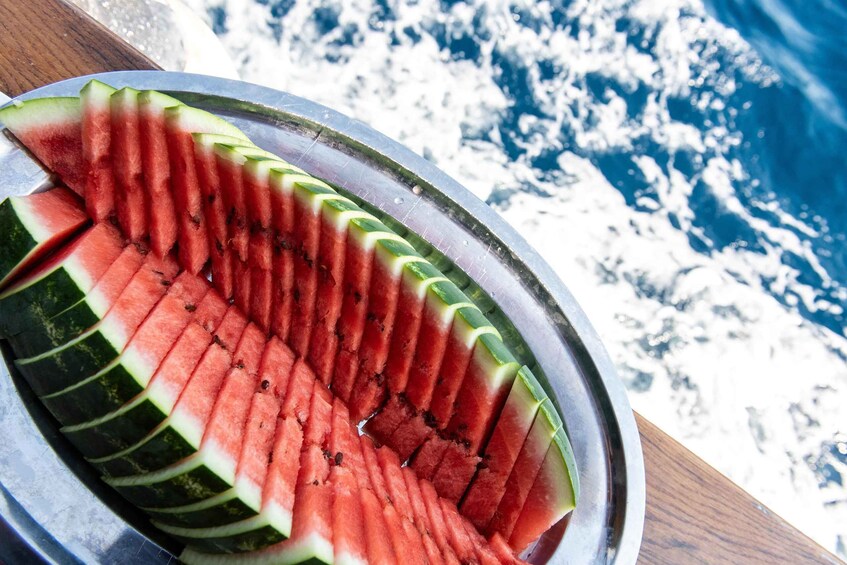 A metal plate with neatly cut watermelon slices arranged in a fan shape. 4