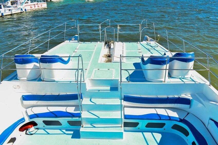 A boat with blue and white seating, metal railings, and a wakeboard. 4