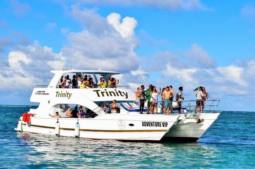 A boat named Trinity with people on board, labeled 'Adventure VIP,' on the water. 1