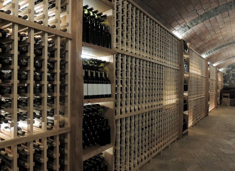 A wine cellar with wooden racks and stone walls. 2