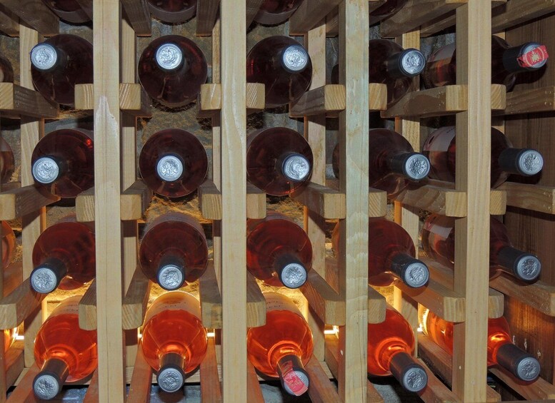 A wooden wine rack with multiple bottles. 3