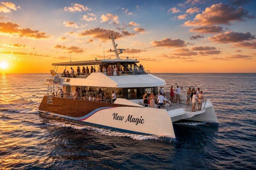 A large boat with 'New Magic' written on its side, sailing on the ocean during sunset. 1