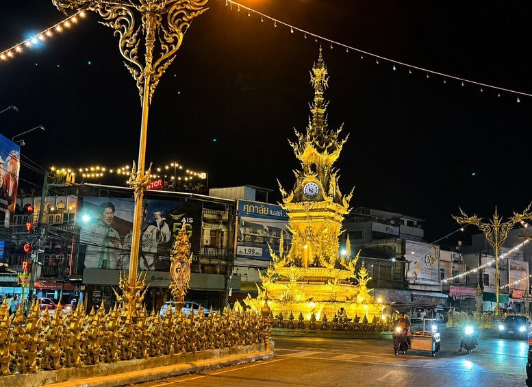 A golden pagoda at night with a clock, surrounded by ornate golden decorations and illuminated by string lights. 4