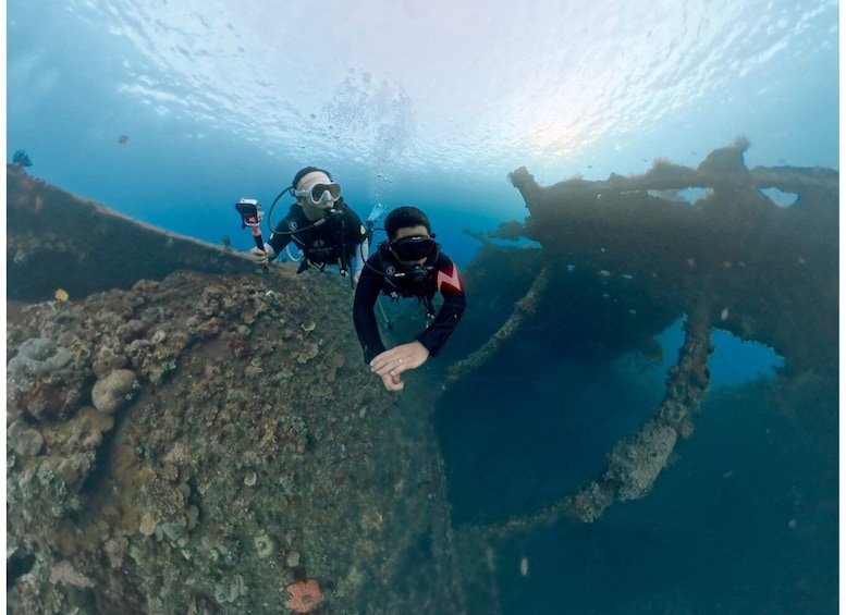 Two divers exploring an underwater wreckage. 5