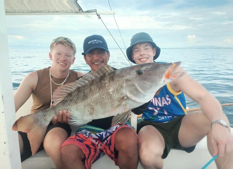 Three people on a boat holding a large fish. 1