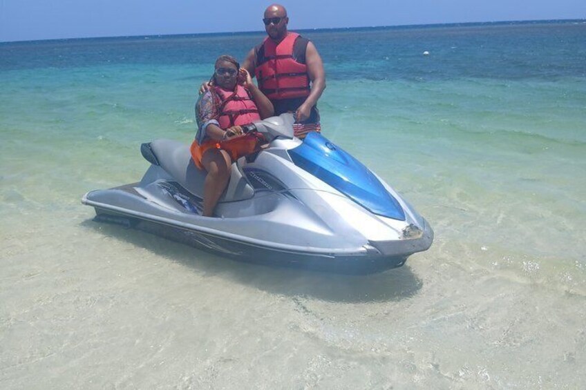 Two people on a jet ski in shallow water. 5