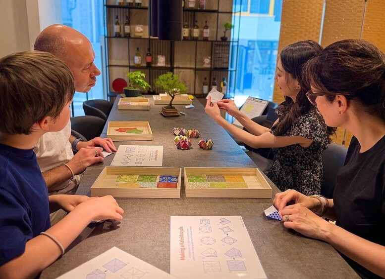 A group of people engaged in a puzzle activity at a table with wooden puzzle pieces and instruction sheets. 5